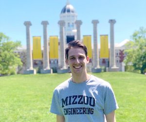 IT Program student Andy Schuster stands in front of the Mizzou columns.