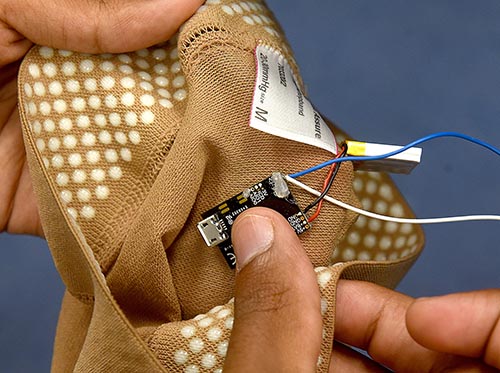 A member of Army Ants shows where a computer chip is place inside a compression sock.