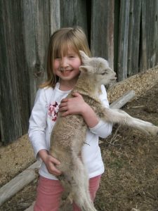 Veronica Fritz as a child holds a lamb.
