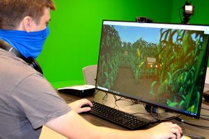 A student looks at a digital corn field on a computer screen.