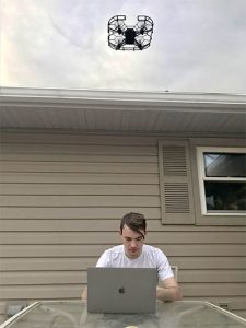 Student controls drone from laptop.