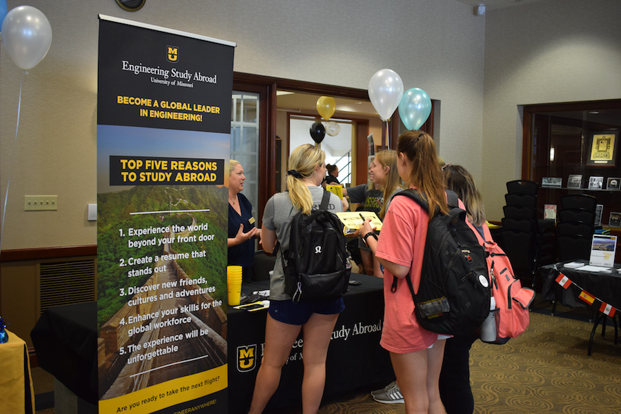 Students cluster around the Mizzou Engineering Study Abroad booth at the study abroad fair.