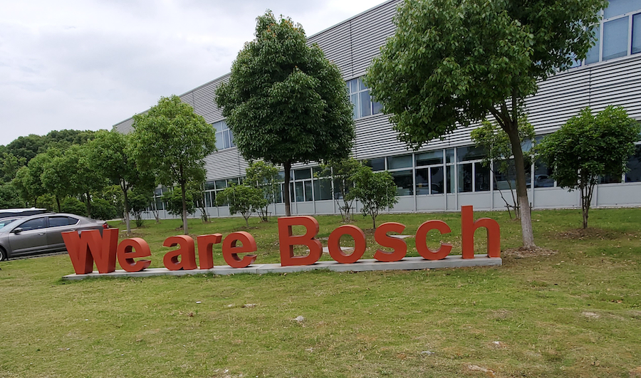 A red sign reading WE ARE BOSCH in front of an office park.