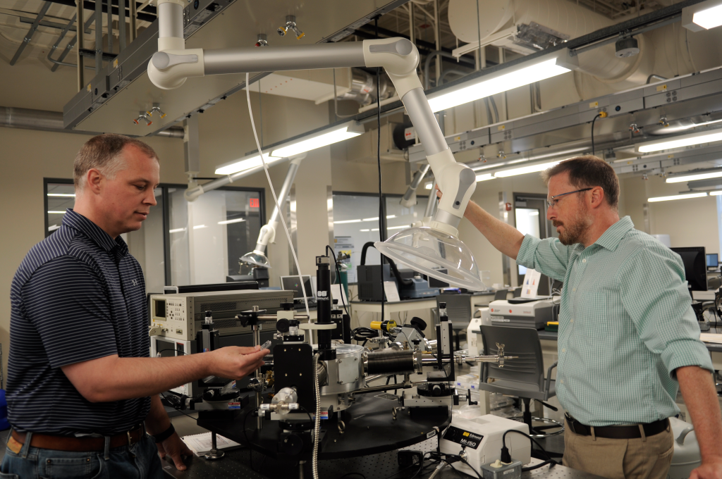 Derek Anderson and Matt Maschmann work in a lab
