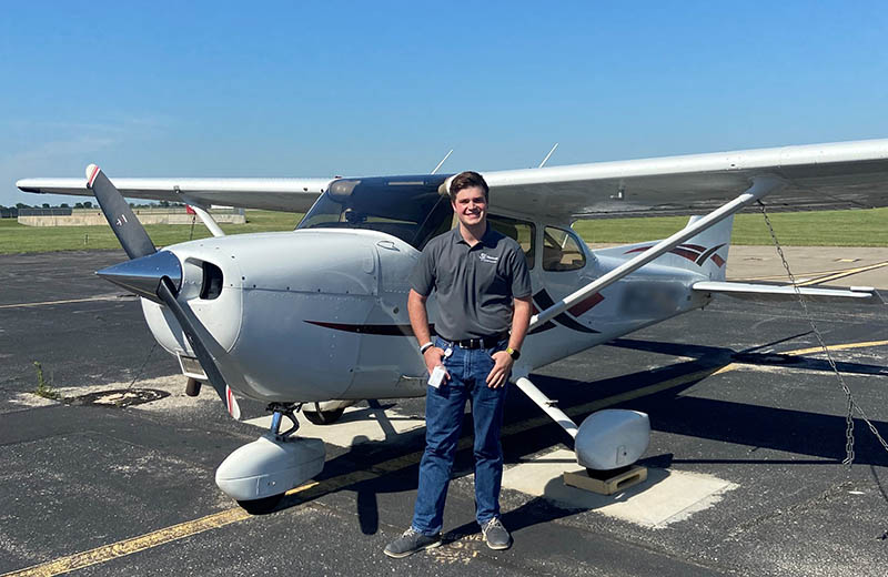 Lane Atchison stands near a plane during his internship at Textron Aviation.