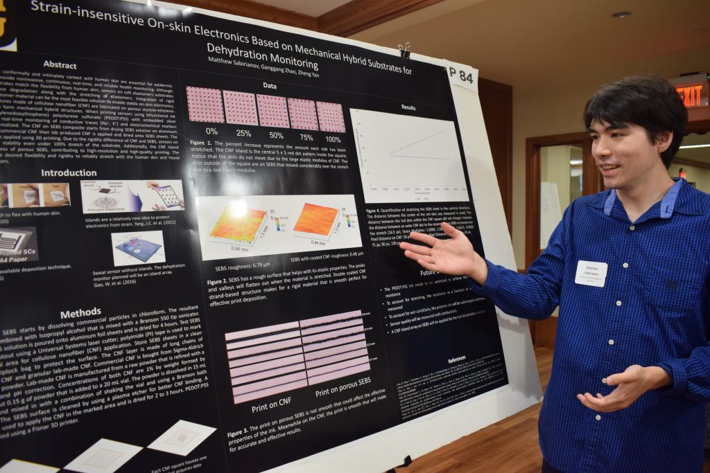 Matthew Sabirianov posing with his research poster
