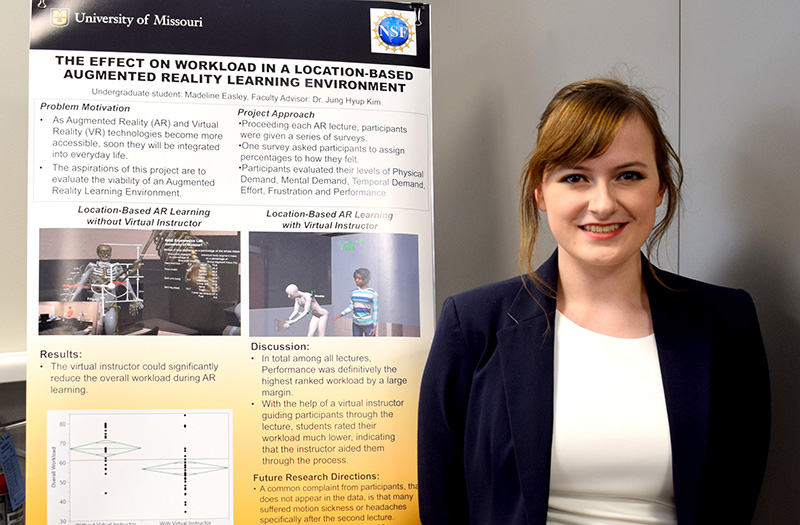 Madeline Easley poses with her research poster.