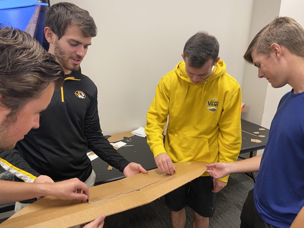 Graham Bond, Ian McDonald, Trent Kempker and Bryce Taylor working on a plane part. They are part of the Mizzou AeroTigers, an aviation-focused club at Mizzou Engineering.