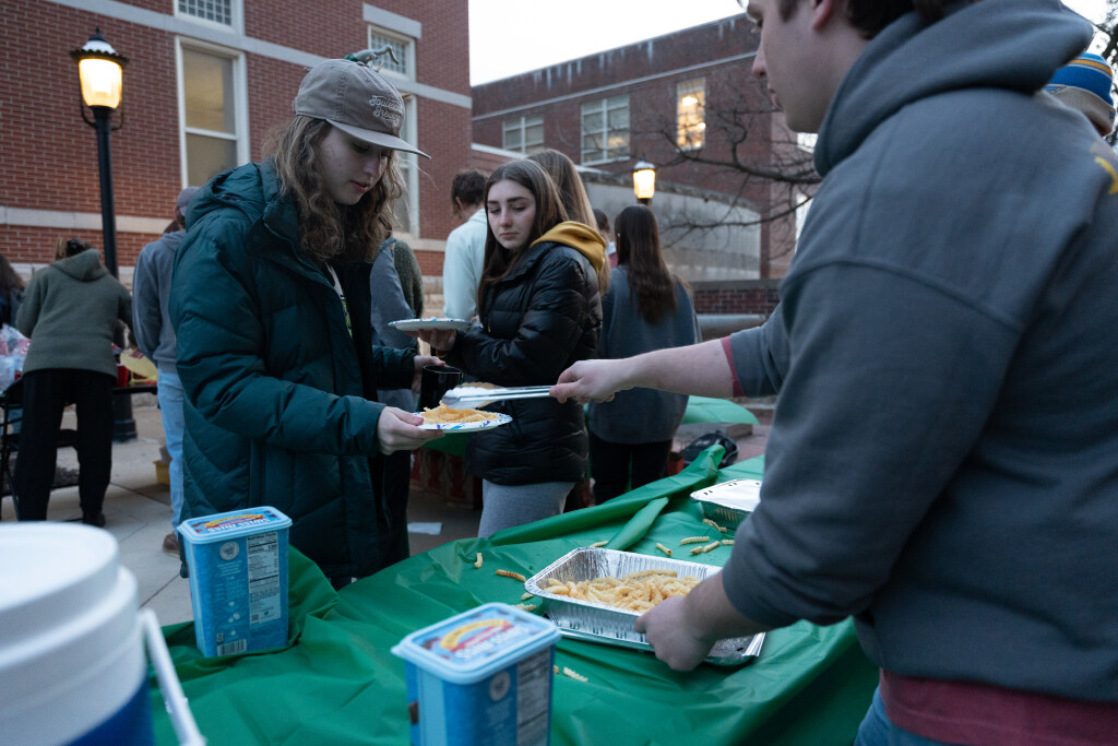 Students serve food at outside station.