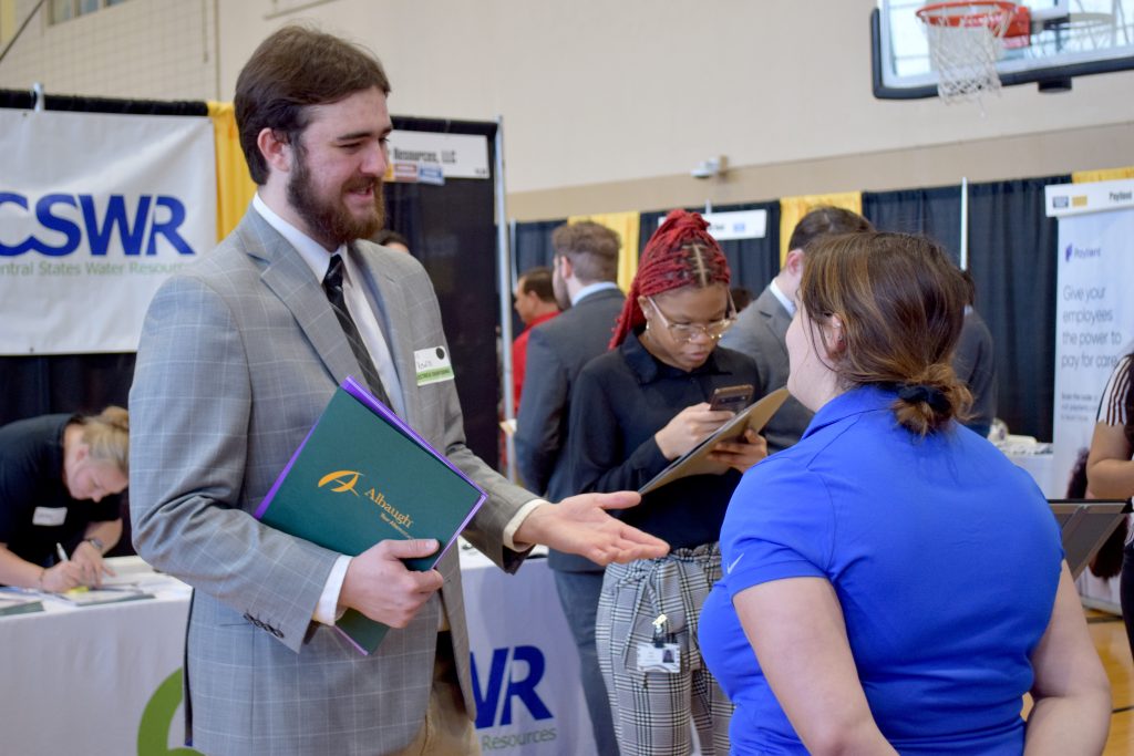 Chris Krewson is an electrical engineering student, pictured here speaking with representatives from Burns and MacDonnell.