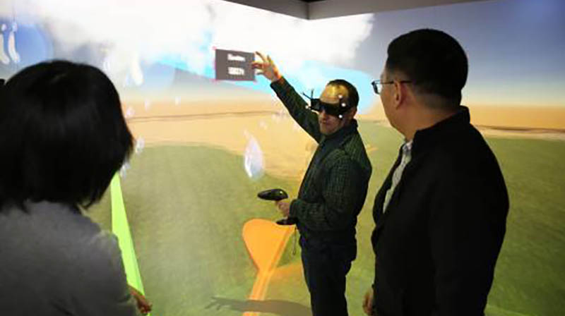Three people using virtual reality inside CAVE facility