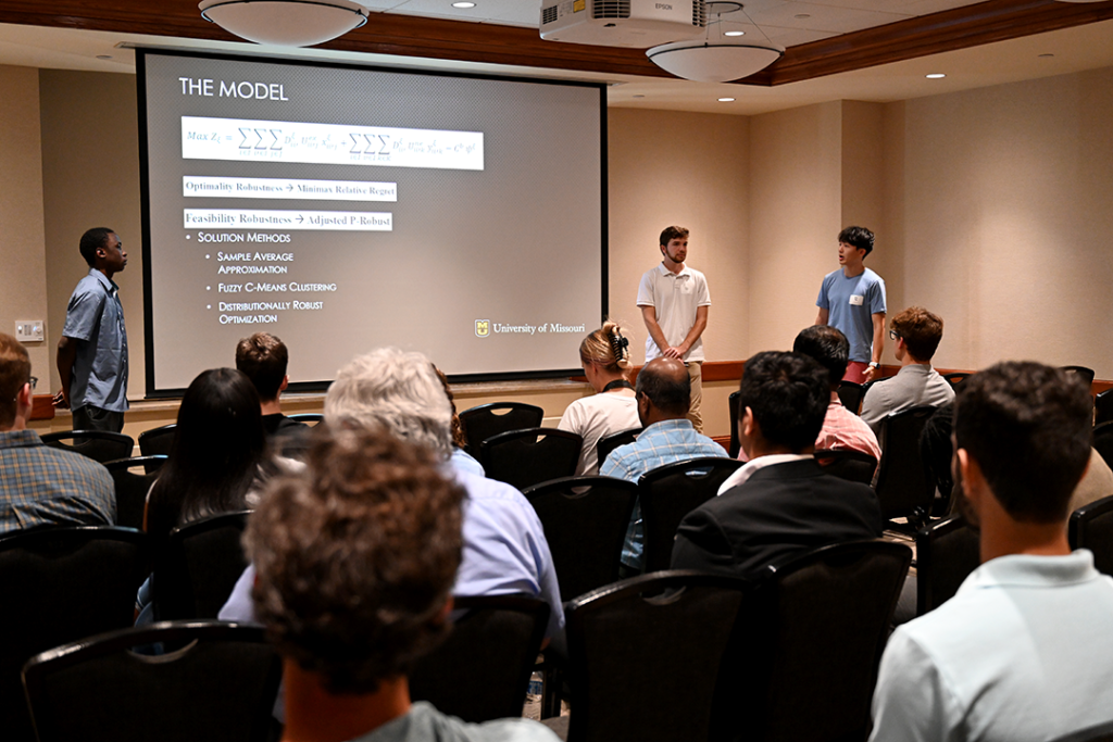 Three students from the AI Enabled REU presenting