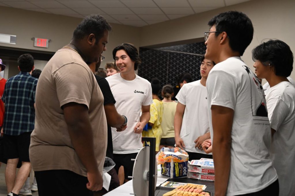 A group of students talk at the BBQ