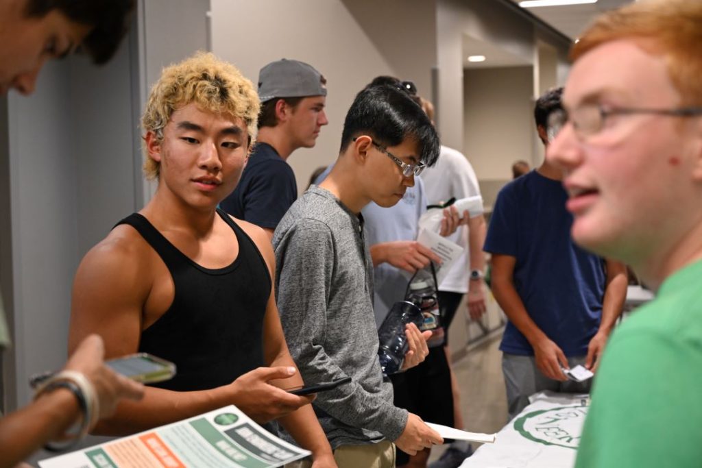 Students read information at a booth at the New Student BBQ.