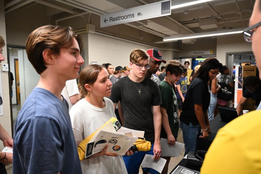 Students receive information at a booth at the BBQ.