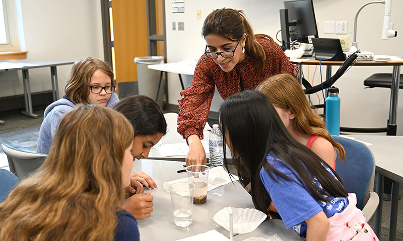 Girls around table looking at water samples