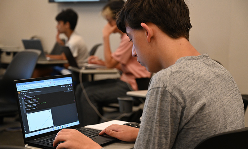Student works with neural models on computer.