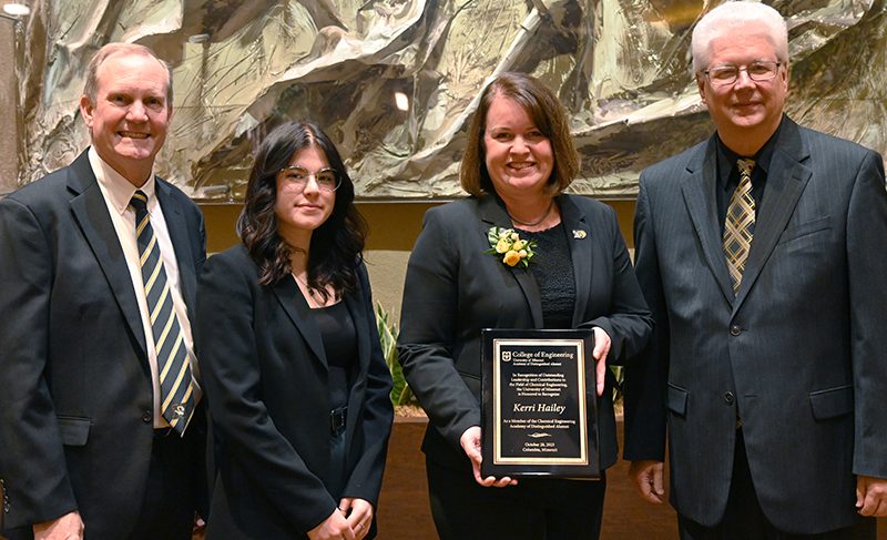 Four people including Kerri Crain Hailey with award