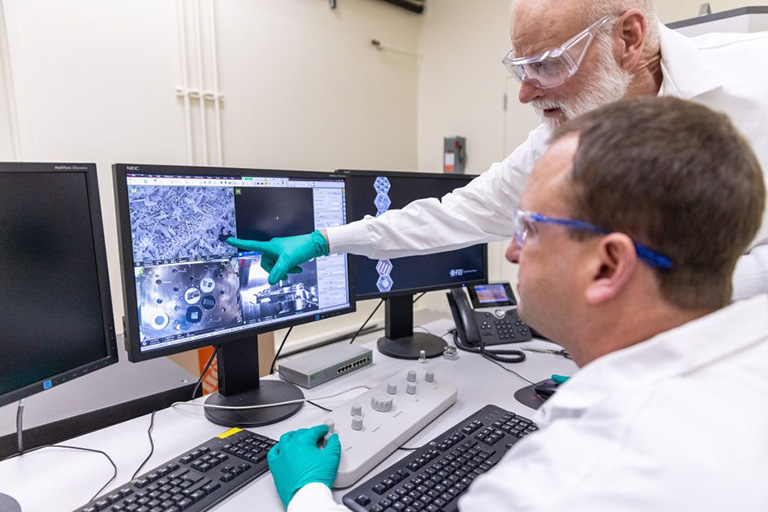 Caleb Philipps and John Gahl (right), senior research scientists at the University of Missouri Research Reactor, examine an image taken from a sample being analyzed by the scanning electron microscope.