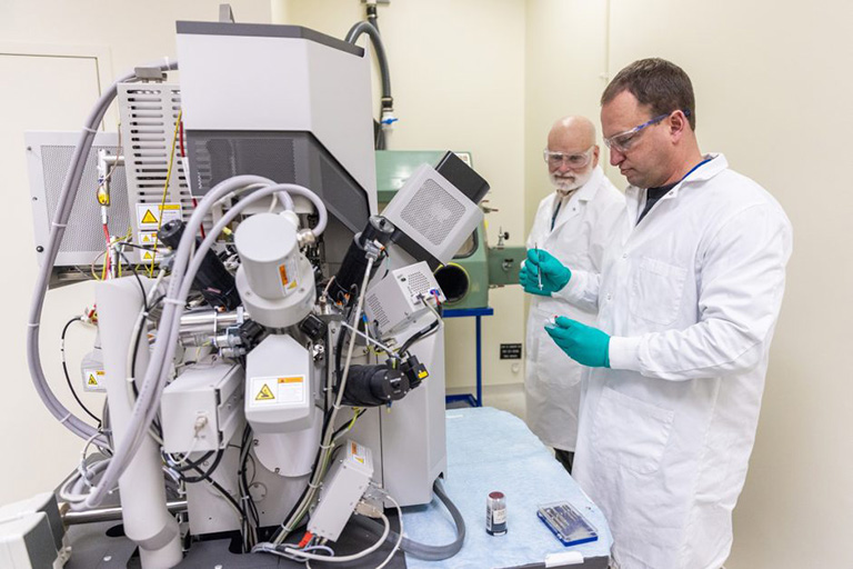 John Gahl (left) and Caleb Philipps, senior research scientists at the University of Missouri Research Reactor, prepare a sample to be loaded into the scanning electron microscope.