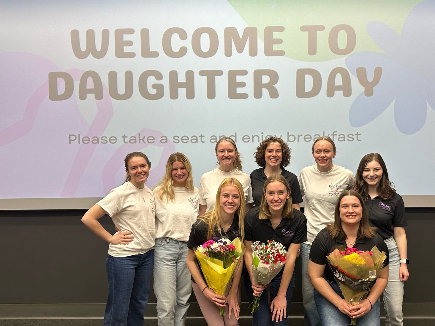 SWE members in front of Welcome to Daughter Day sign