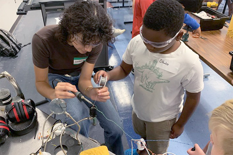 student and instructor at underwater robotics camp