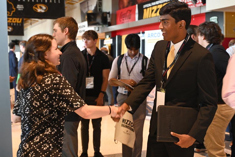 Student shaking hands with employer at fall 2024 career fair