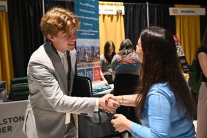 Student shaking hands with employer at fall 2024 career fair