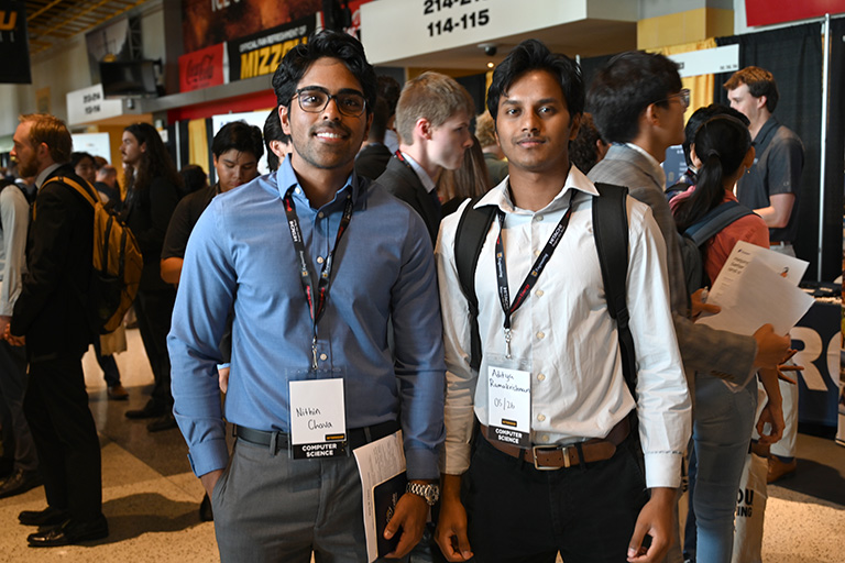 Two students posed, smiling at career fair