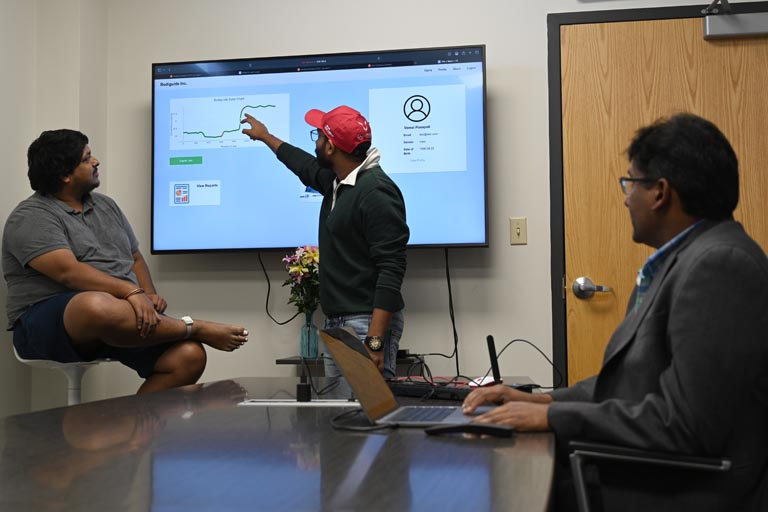 Graduate student researchers with Prasad Calyam looking at anklet sensor data