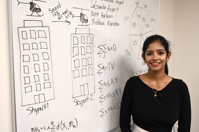 Rajendran in front of whiteboard with writing on it