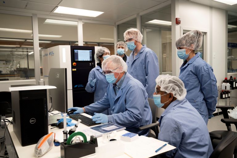 Faculty and students working on computer next to Nanoscribe 3D Printer