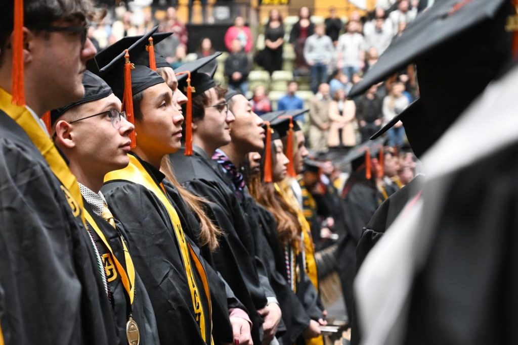 Graduates standing at the 2024 December commencement ceremony