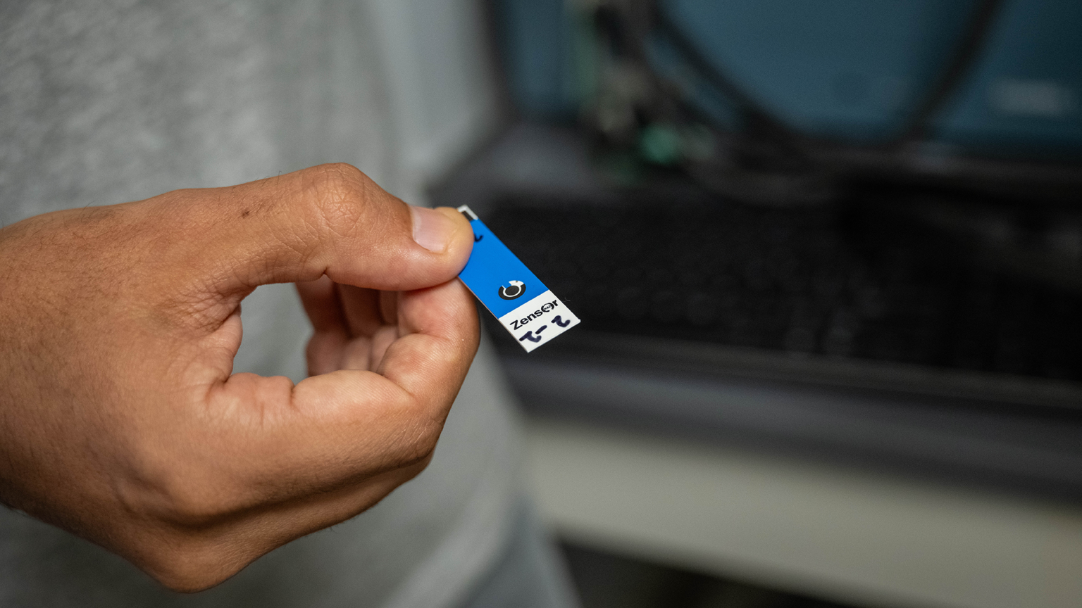 Close up of a hand handing a small medical sensor