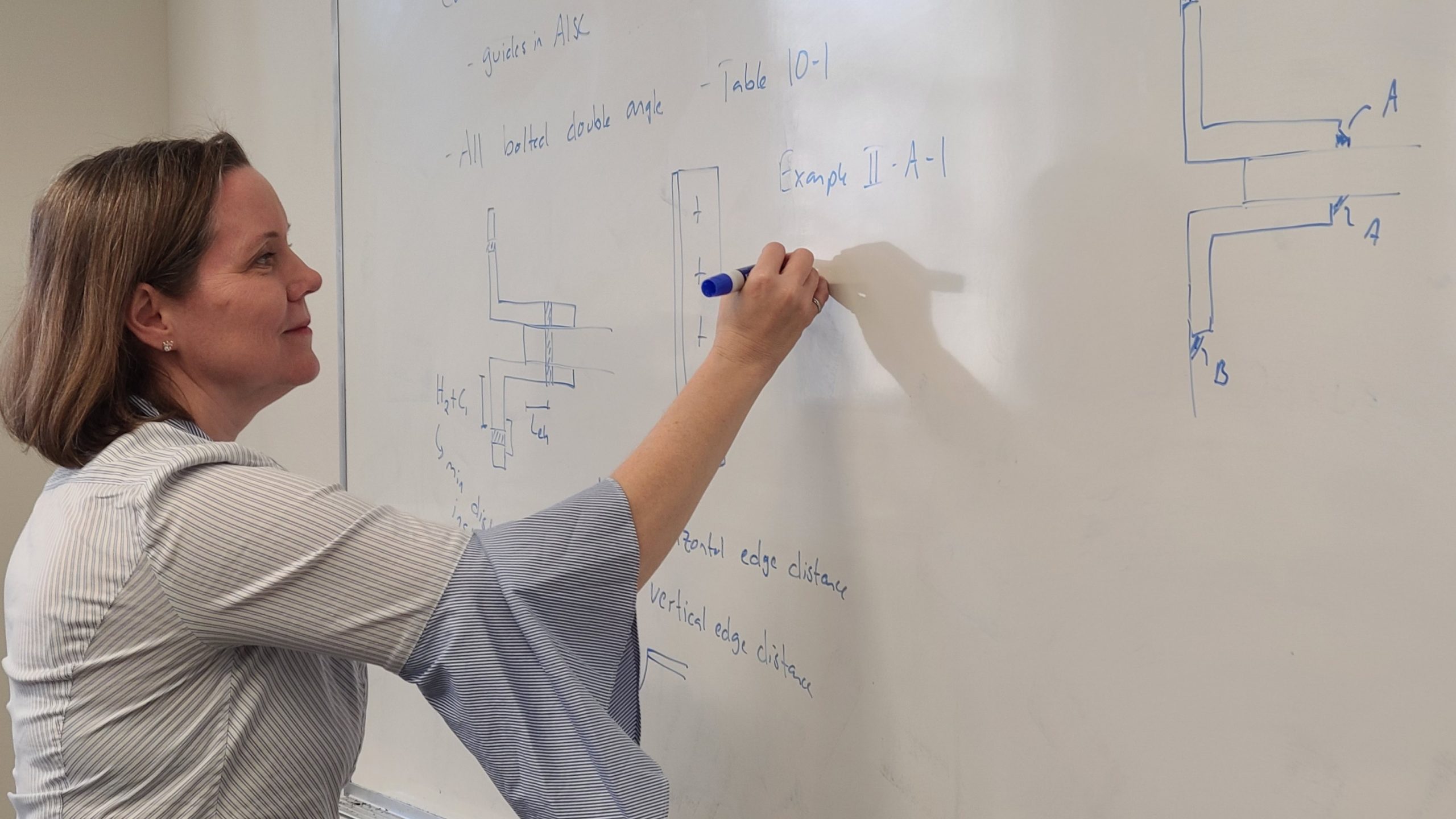 Sarah Orton writes on a classroom white board