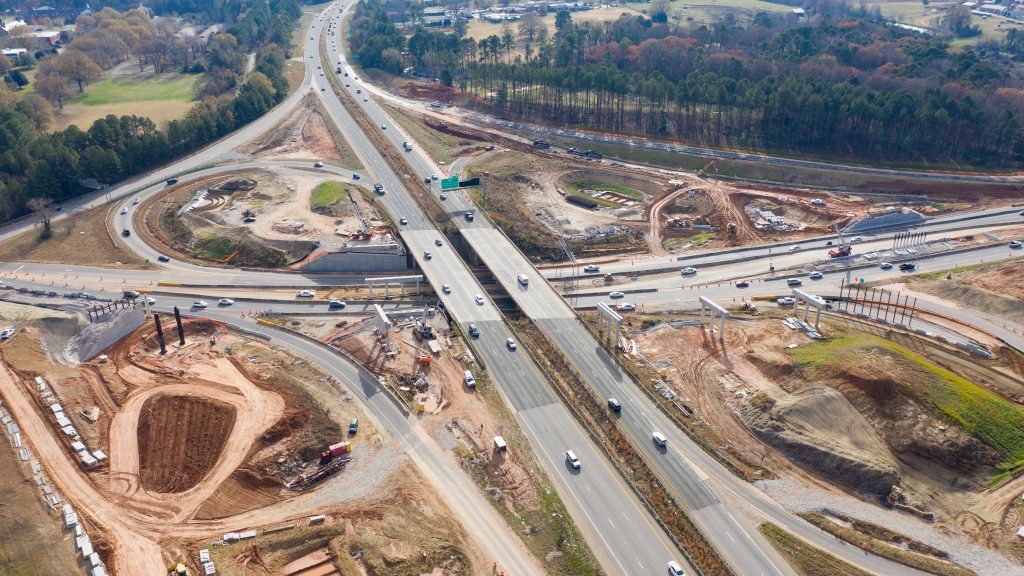Aerial view of four-lane highway interchange under construction