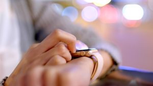 A woman interacts with her smartwatch