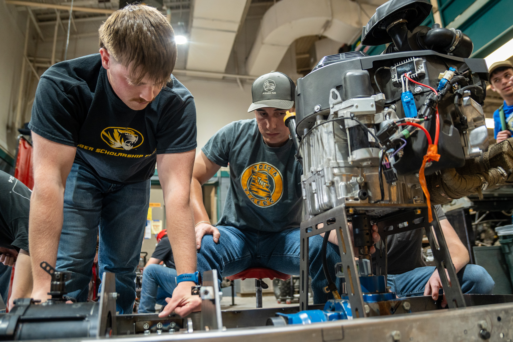 Members of Mizzou Quarter Scale Tractor Pulling Team work on their tractor in their workshop
