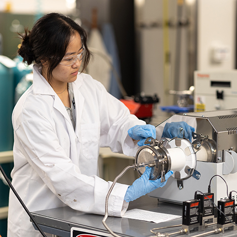 Women in a white lab coat works in a lab