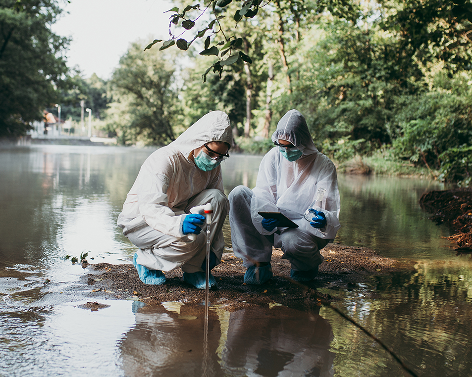 Two people in PPE getting samples from water
