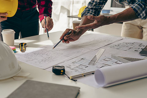 Hands working on a building plan