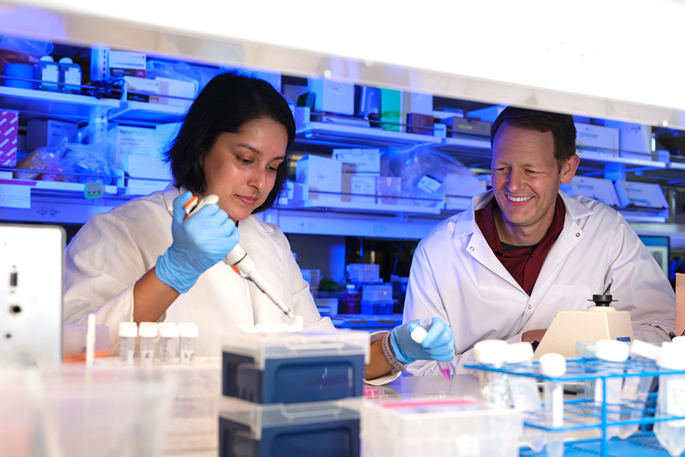 Bret Ulery and a student work in a lab