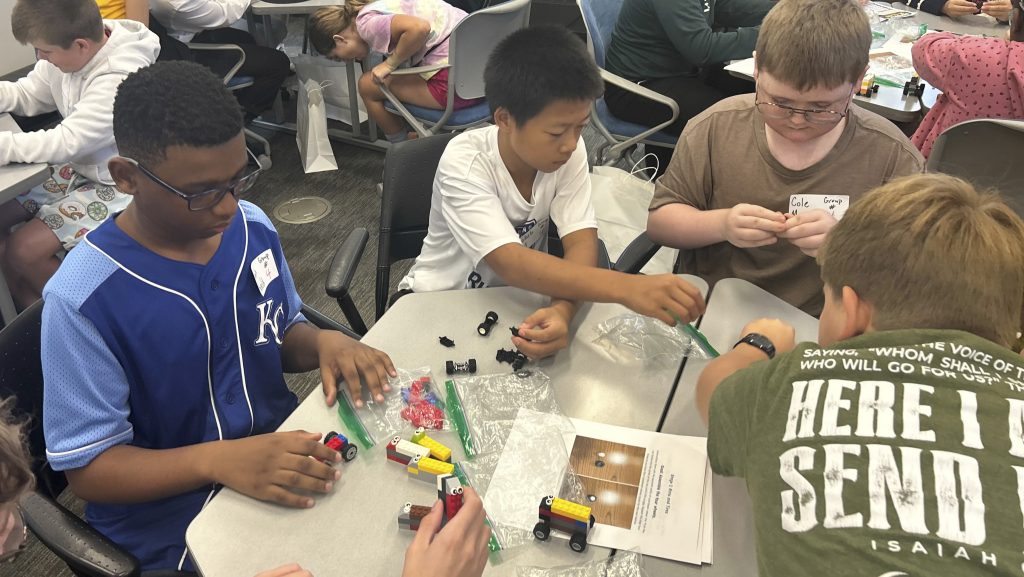 Campers assemble a production line from Legos blocks.