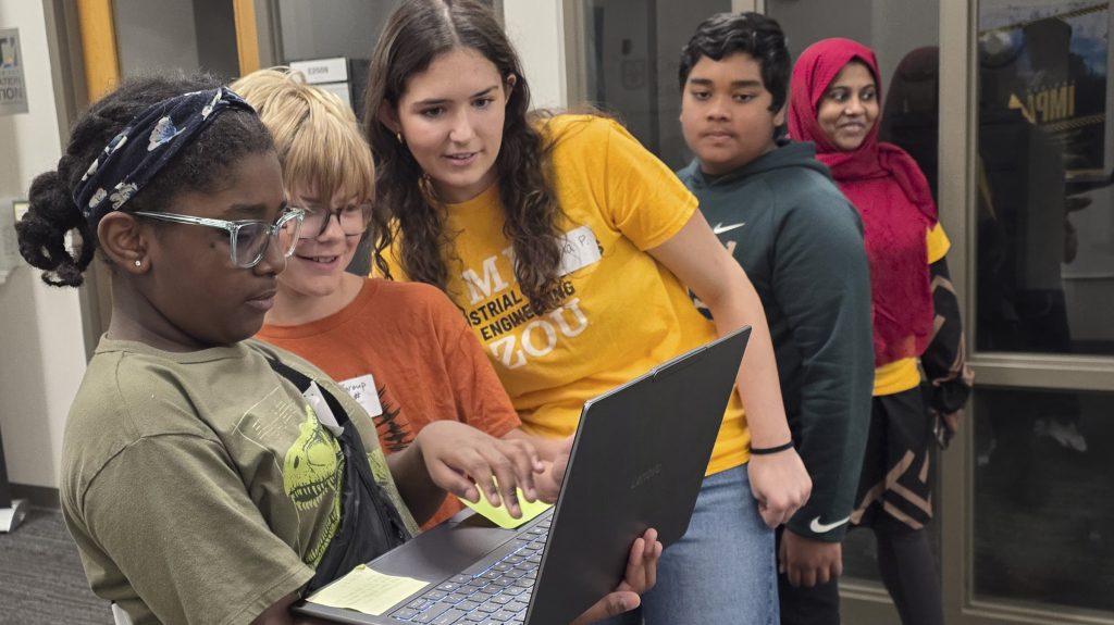 Camp participants share their work with a Mizzou student