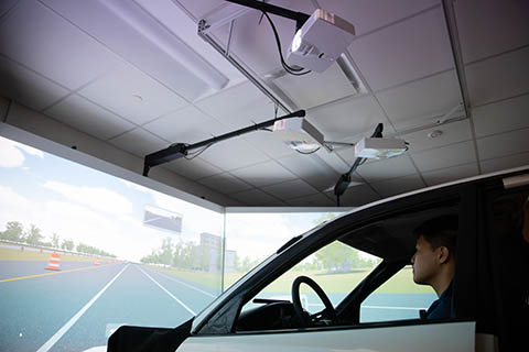 Man sits in a car simulator