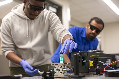 A professor and students work together in a laboratory.    